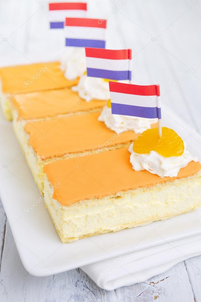 Orange tompouce, traditional Dutch pastry, on a rustic table