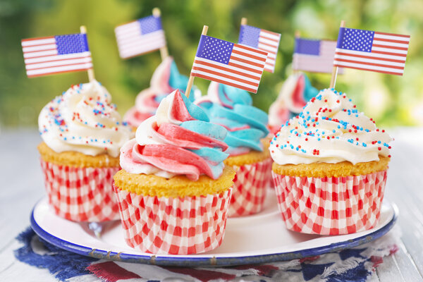 Cupcakes with red-white-and-blue frosting and American flags