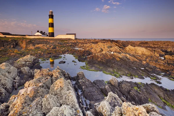 Farol na Irlanda do Norte ao pôr do sol — Fotografia de Stock