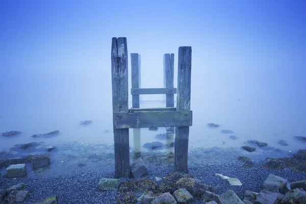 Jetty no mar em uma manhã nebulosa ao amanhecer — Fotografia de Stock