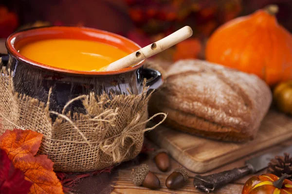 Hausgemachte Kürbissuppe auf einem rustikalen Tisch mit herbstlicher Dekoration — Stockfoto