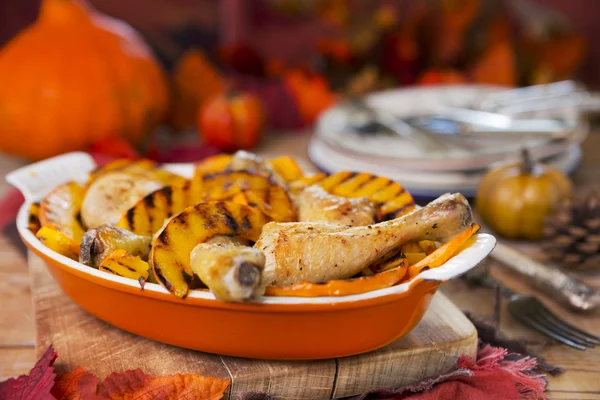 Horno de pollo asado con calabaza a la parrilla en una mesa rústica — Foto de Stock