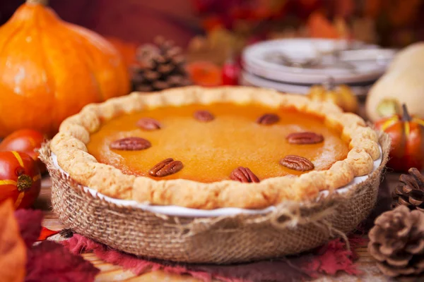 Hausgemachter Kürbiskuchen auf einem rustikalen Tisch mit herbstlicher Dekoration — Stockfoto