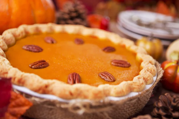 Hausgemachter Kürbiskuchen auf einem rustikalen Tisch mit herbstlicher Dekoration — Stockfoto