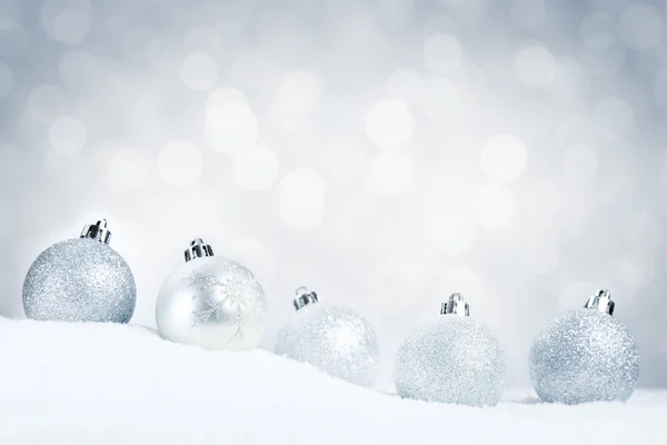 Boules de Noël en argent sur neige avec un fond argenté — Photo