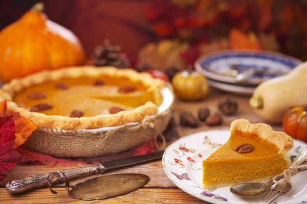 Torta de abóbora caseira em uma mesa rústica com decorações de outono — Fotografia de Stock