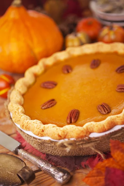 Homemade pumpkin pie on a rustic table with autumn decorations — Stock Photo, Image