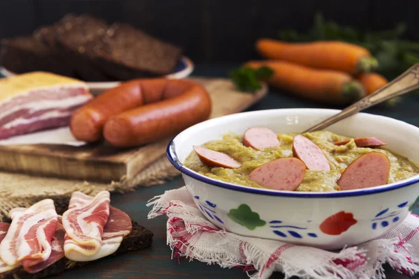 Sopa de guisantes holandesa tradicional e ingredientes en una mesa rústica — Foto de Stock