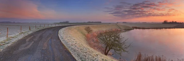 Typical Dutch landscape with a dike, in winter at sunrise — Stock Photo, Image