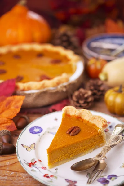 Torta de abóbora caseira em uma mesa rústica com decorações de outono — Fotografia de Stock