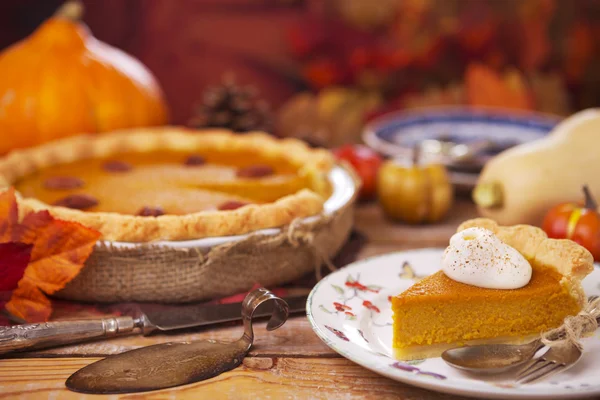 Tarta de calabaza casera sobre una mesa rústica con decoraciones otoñales — Foto de Stock