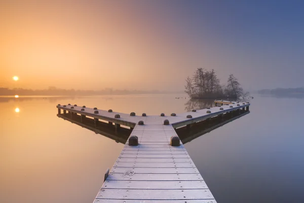 Molo na klidného jezera na mlhavé zimní ráno — Stock fotografie