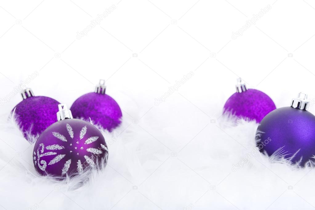 Christmas baubles on a feathery surface, brightly lit