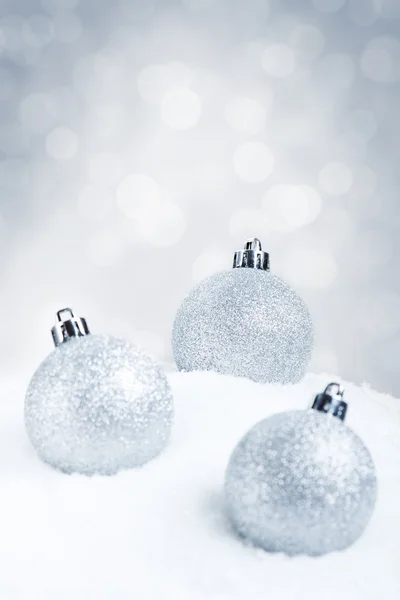 Baldes de Natal de prata na neve com um fundo de prata — Fotografia de Stock