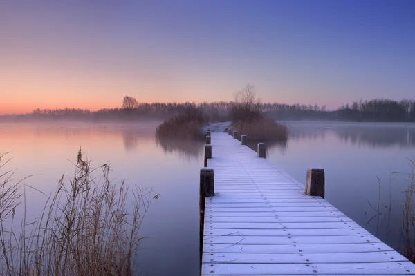 Dřevěný chodník na jezeře za svítání v zimě, Nizozemsko — Stock fotografie