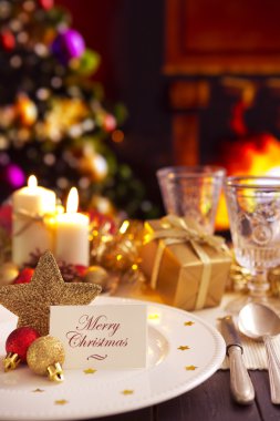 Christmas table with fireplace and Christmas tree in the background