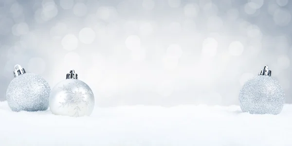 Palline di Natale in argento sulla neve con sfondo argento — Foto Stock
