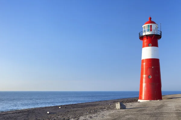 Röd och vit fyr och en klarblå himmel — Stockfoto