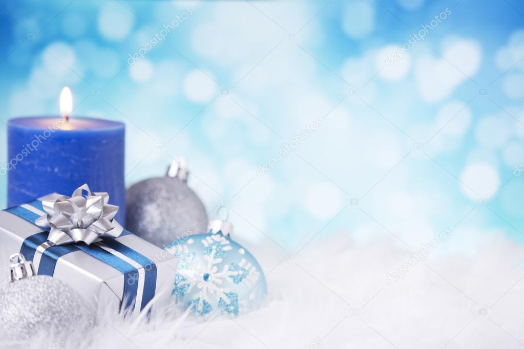 Blue and silver Christmas scene with baubles, gift and candles