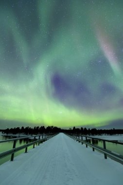 Aurora borealis over a bridge in winter, Finnish Lapland clipart