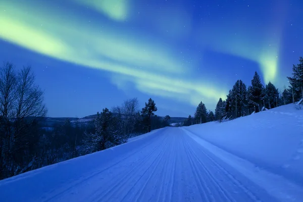 Norrsken över en väg genom vinterlandskapet, finska La — Stockfoto