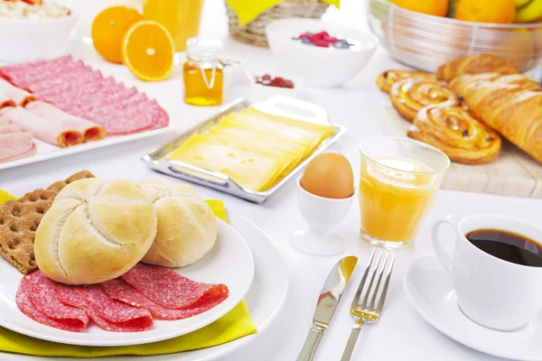 Mesa llena de platos de desayuno continental, muy iluminada — Foto de Stock