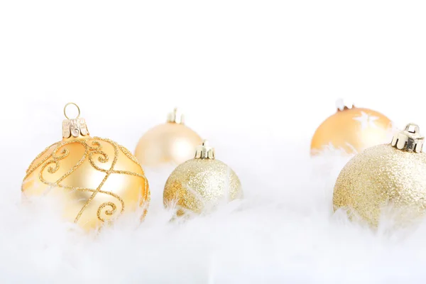 Boules de Noël sur une surface plumeuse, brillamment éclairées — Photo