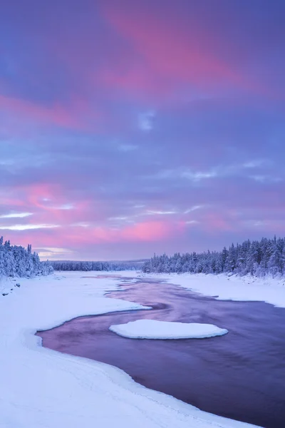 Zonsopgang boven de rivier de stroomversnellingen in een winterlandschap, Fins Lapland — Stockfoto