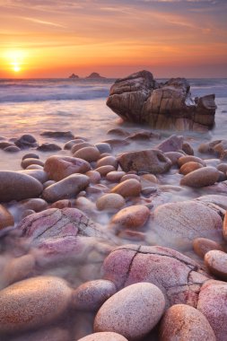 Kayalık plaj gün batımında, Porth Nanven, Cornwall, İngiltere