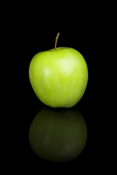 Green apple on a black reflective background — Stock Photo, Image
