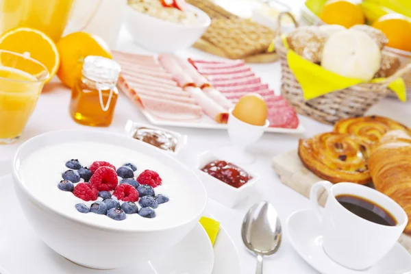 Mesa llena de platos de desayuno continental, muy iluminada —  Fotos de Stock