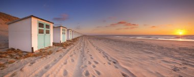 Row of beach huts at sunset, Texel island, The Netherlands clipart