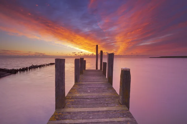 Jetty à beira-mar ao nascer do sol na ilha de Texel, Holanda — Fotografia de Stock