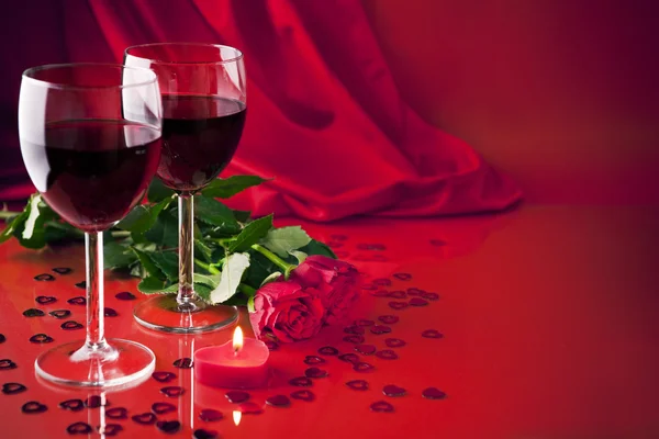 Vasos con vino, una vela y rosas — Foto de Stock