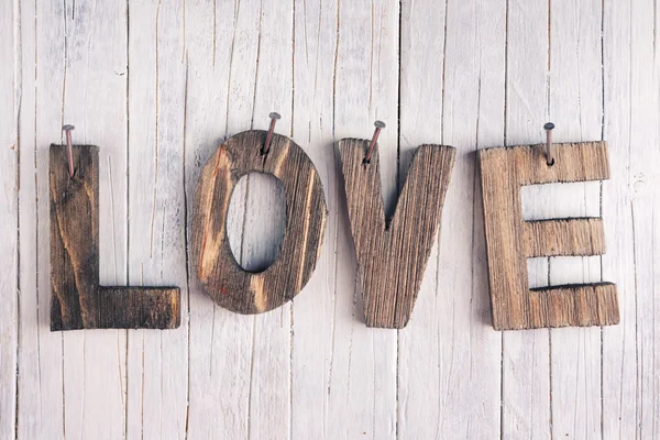 La palabra 'amor' en letras de madera sobre un fondo rústico —  Fotos de Stock