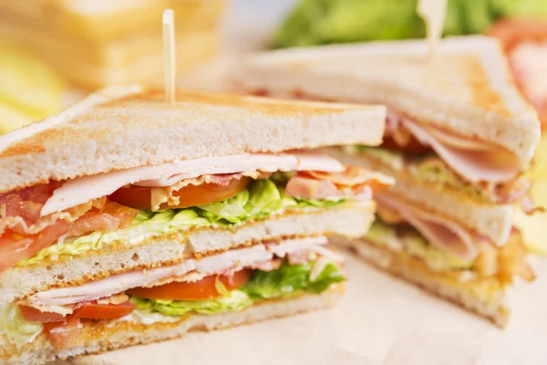 Club-Sandwich auf rustikalem Tisch im hellen Licht — Stockfoto