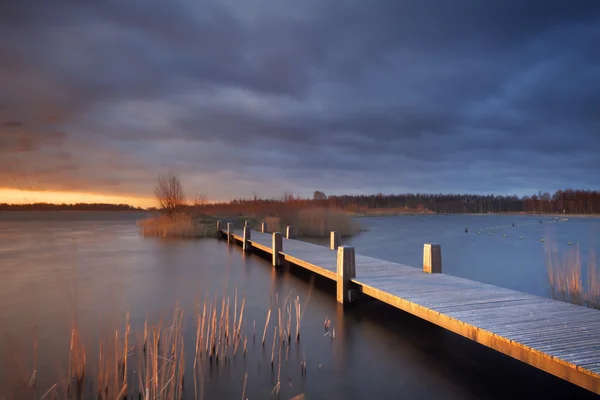 Paseo marítimo sobre un lago bajo cielos tormentosos en los Países Bajos — Foto de Stock