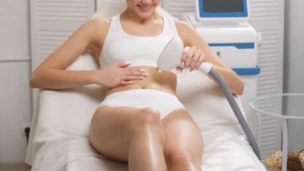 Donna attraente che fa la procedura di epilazione laser da sola. — Video Stock
