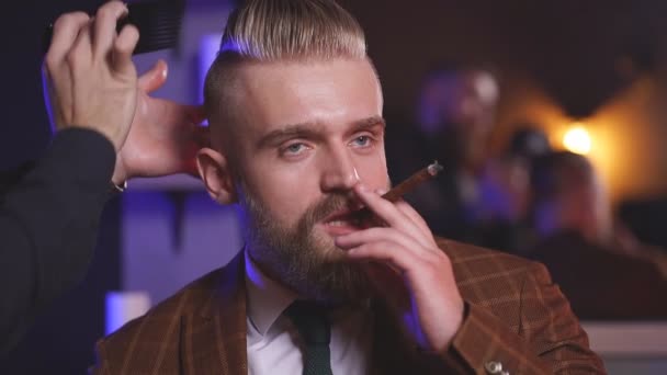 理发师在沙龙里为抽烟的商人做发型 — 图库视频影像