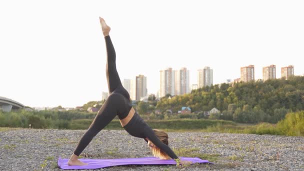 Fitness meisje doet yoga, fitness en stretching oefening in het park. Stockvideo's