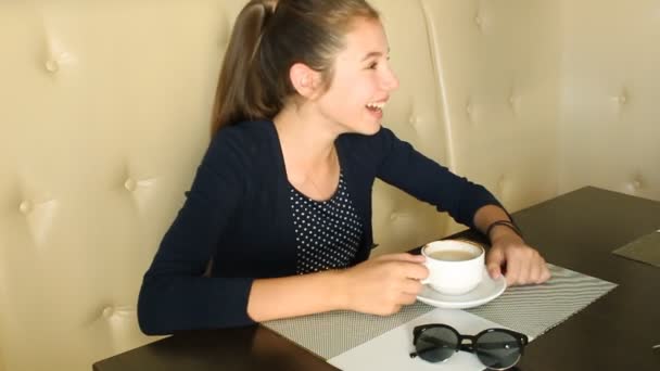 Dziewczyna, picia kawy i rozmawia przez telefon — Wideo stockowe