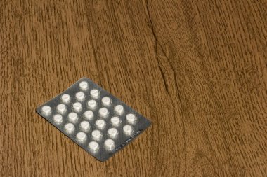 Ahşap yüzeyde bir tablet hap. 25) hap. 