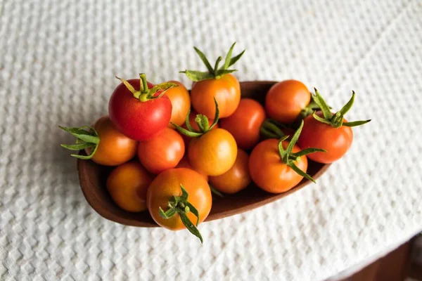 木製のボウルにチェリートマト 小さいトマト 背景の白いテーブルクロス — ストック写真