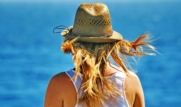 Una mujer joven mira pensativamente un mar — Foto de Stock