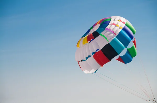 Colorido paracaídas redondo contra el cielo azul — Foto de Stock