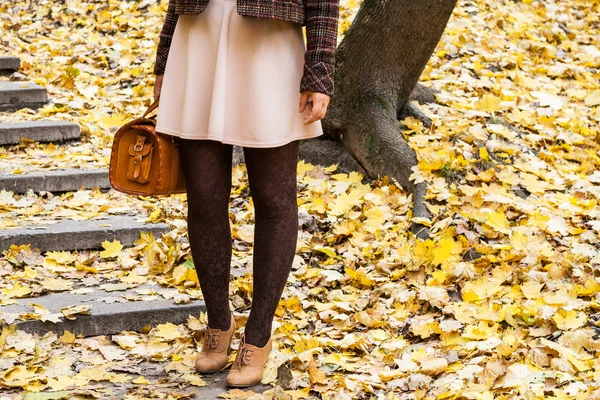 Women's feet are on the stairs in the park with golden autumn le — Stock Photo, Image