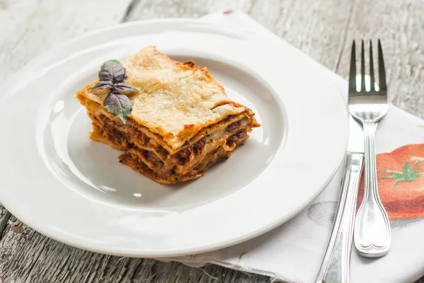 Porzione di lasagne bolognese su un piatto bianco — Foto Stock