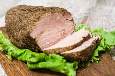 Soğuk haşlanmış domuz eti bir kesim salata yaprakları ile