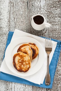 Şurup, reçel ve ahşap masaya çiçek ile Pancakes