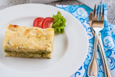 ıspanak bir tabak ve çatal bıçak takımı ile patates güveç